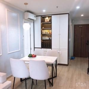 a dining room with a white table and white chairs at The Manor Crown T12 in Thôn Trường Giang