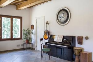 a room with a piano and a clock on the wall at Djenga - rock 'n rooms in Genga