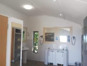Baño blanco con lavabo y aseo en Elwai centre Safari Tent, en Heni Village