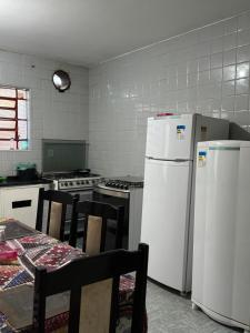 een keuken met 2 koelkasten en een tafel en stoelen bij Quarto privativo com ótima localização in Sao Paulo