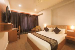 a hotel room with a bed and a television at Happy Stays Whitefield in Bengaluru +34 photos