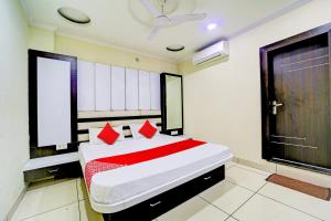 1 dormitorio con 1 cama grande con almohadas rojas en OYO SPOT ON Hotel My Lord en Bhopal