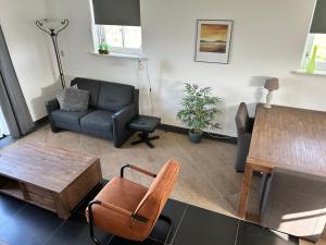 un soggiorno con divano e tavolo di Landhuis Mariëtta a De Koog