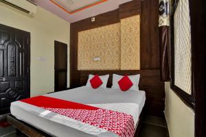 a bedroom with a large bed with red pillows at OYO Flagship Hotel Lux Inn in Udaipur