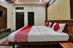 a bedroom with a large bed with red and white sheets at OYO Flagship Hotel Lux Inn in Udaipur
