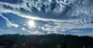ein wolkiger Himmel mit der Sonne in der Mitte in der Unterkunft Pod 20 in Jelenia Góra