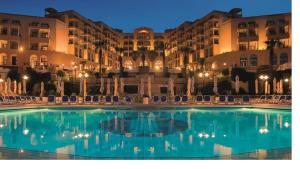 a swimming pool in front of a hotel at night at Bayview in St Julian's