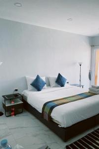 a bedroom with a large bed with blue pillows at Sasimanta in Kamala Beach