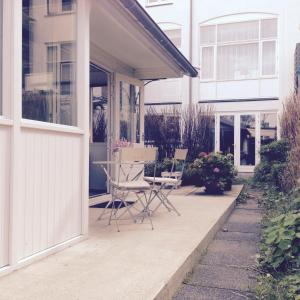 eine Terrasse mit einem Tisch und Stühlen auf einem Haus in der Unterkunft Tiny House Madame Jeanette in Zandvoort