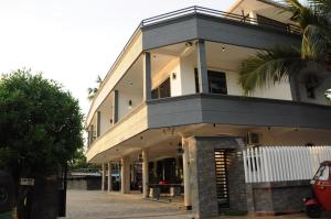 River Top Holiday Resort في Bandaragama: مبنى امامه نخله