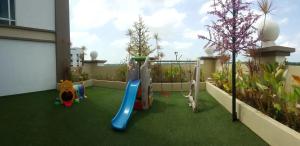 a playground on a balcony with green grass at De Viana Apartments Homestay in Kota Bharu