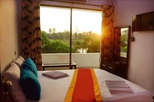 um quarto com uma cama e uma grande janela em River Top Holiday Resort em Bandaragama