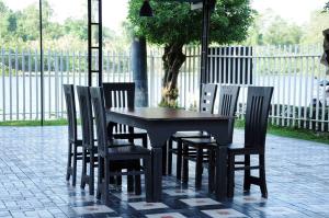 a black table and chairs with a tree and a fence at River Top Holiday Resort in Bandaragama