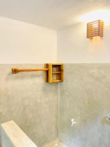 a bathroom with a wooden shelf on the wall at Rivinu Place Arugambay in Arugam Bay +104 photos