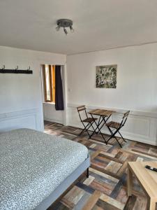 1 dormitorio con 1 cama, mesa y sillas en La Brionnaise Studio, en Brionne