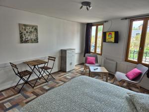 1 dormitorio con 1 cama, mesa y sillas en La Brionnaise Studio, en Brionne
