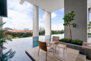 a balcony with chairs and a table and a large window at Lumi Tropicana by Nexus Homes in Petaling Jaya