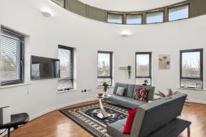 een woonkamer met een bank en een tv bij Livestay - Two Bed London Apt with Balcony in Colindale
