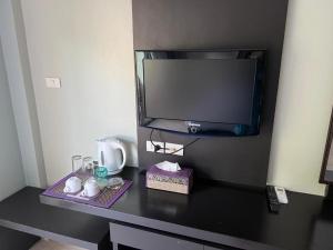 a desk with a tv and a table with cups at L&P Guesthouse in Kata Beach