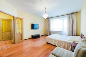 a hotel room with a bed and a tv at Dekabrist apartment on Petrovsko-Zavodskaya 25 in Chita
