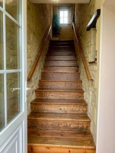 una escalera con escalones de madera en un edificio en Maison à louer, en Noron-la-Poterie