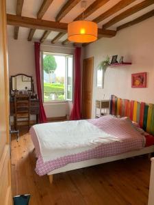 1 dormitorio con cama y ventana en Maison à louer, en Noron-la-Poterie