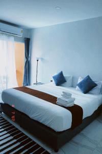 a bedroom with a large bed with blue walls at Sasimanta in Kamala Beach