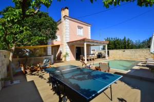 ein Haus mit einem Pool und einem Tisch mit in der Unterkunft Villa Ithaca in Varípetron