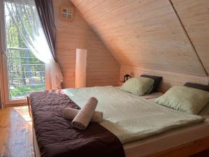 a large bed in a wooden room with a window at Resort EDEN domki, apartamenty i pokoje in Jastrzębia Góra