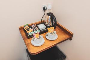 a table with two cups and a coffee maker at The Auberge in Yaxley