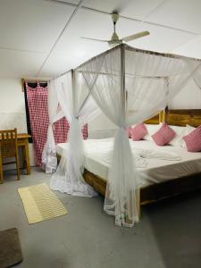 um quarto com uma cama e uma rede mosquiteira em Swiss kiss beach resort em Uppuveli