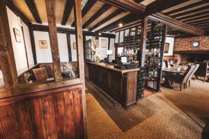 um quarto com paredes de madeira e um bar com garrafas de vinho em The Auberge em Yaxley