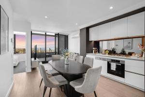 een keuken en eetkamer met een tafel en stoelen bij NEW Waterfront Living With Sublime Views 2B1B in Melbourne