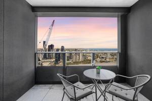 een balkon met een tafel en stoelen en uitzicht op de stad bij NEW Waterfront Living With Sublime Views 2B1B in Melbourne