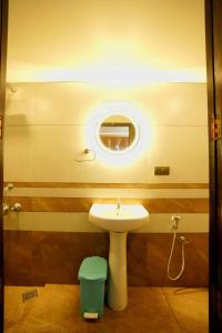 uma casa de banho com um lavatório e um espelho em IndraprasthamLakeCruise em Alappuzha