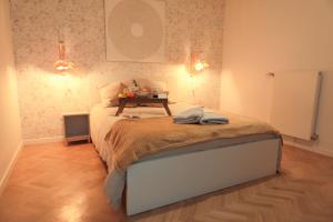 um quarto com uma cama com uma mesa em Le Cèdre, appartement neuf et décoration soignée em Fontenay-sous-Bois
