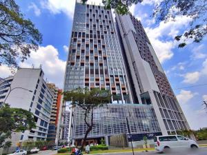 un edificio alto con un coche aparcado delante de él en Lumi Tropicana by Nexus Homes en Petaling Jaya