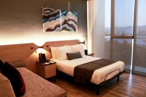 une chambre d'hôtel avec un lit et une fenêtre dans l'établissement QUARTZ HOTEL & SPA, à Tijuana