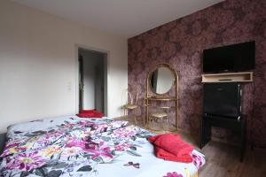 - une chambre avec un lit, une télévision et un miroir dans l'établissement Gästehaus Senger, à Bestwig