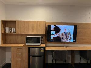 a tv sitting on a desk with a computer on it at Katherine Motel in Katherine