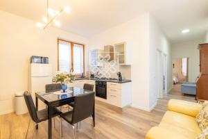 cocina y comedor con mesa y sillas en Gouenael Apartment- Castelsardo, en Castelsardo