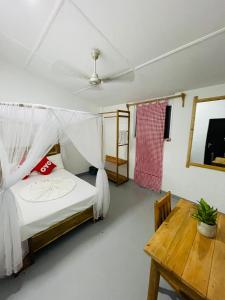 a bedroom with a bed and a table and a ceiling at Swiss kiss beach resort in Uppuveli