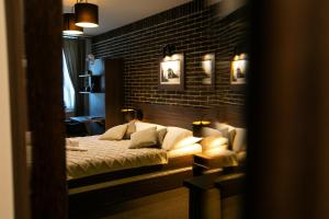 a bedroom with a bed and a brick wall at Penzion U Kubesa - Adults only in Kroměříž