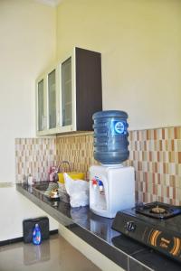 eine Küchentheke mit einer Kaffeekanne auf der Mikrowelle in der Unterkunft Vila Mulyo cordoba residence E4 in Tlekung + 10 Fotos