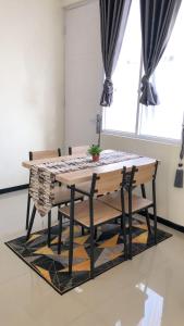 einen Esstisch und Stühle mit Tisch und Fenster in der Unterkunft Vila Mulyo cordoba residence E4 in Tlekung