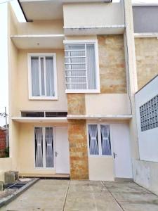 ein Gebäude mit zwei Fenstern und zwei Türen in der Unterkunft Vila Mulyo cordoba residence E4 in Tlekung