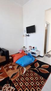 ein Wohnzimmer mit einer Couch und einem Teppich in der Unterkunft Vila Mulyo cordoba residence E4 in Tlekung