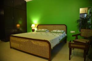 a green bedroom with a bed and a green wall at Himtrek Stays Delhi in New Delhi