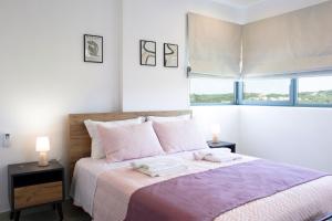 a white bedroom with a large bed with two lamps at Rose Cozy Getaway - 3 Pearls Pool Retreat in Dhémbla
