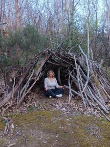a woman sitting inside of a pile of wood at Gite de la melisse in Lairière +2 photos